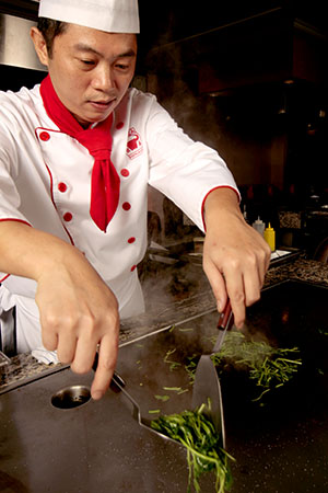 Un cocinero teppanyaki prepara verduras en una parrilla caliente. Foto de Jeff Lawrence
